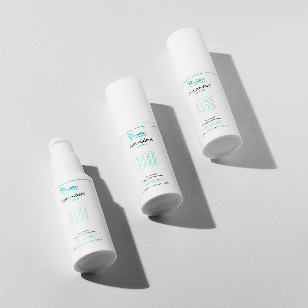 Drei weiße Kosmetikflaschen mit der Aufschrift "Antioxidant" auf hellem Hintergrund.